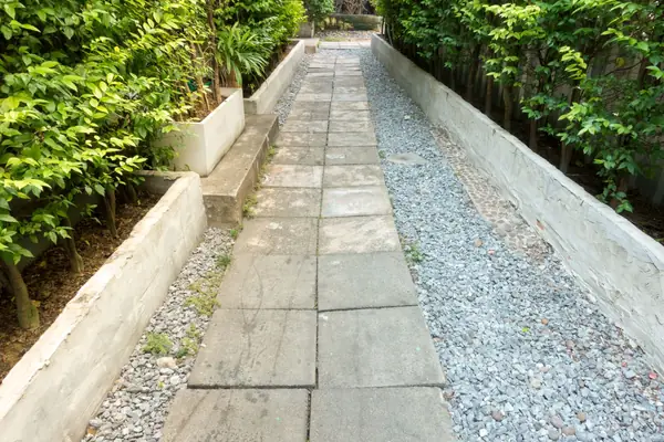 Paver walkway running between low retaining walls and plantings